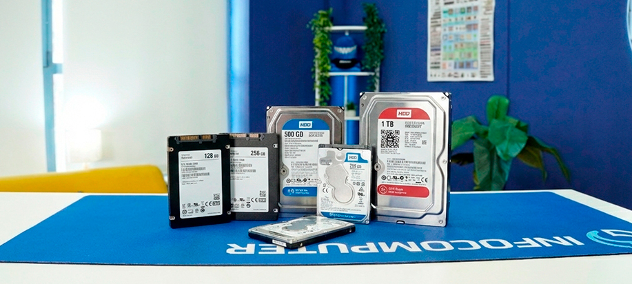 Discos duros HDD y SSD de diferentes capacidades para portatiles y ordenadores de sobremesa sobre mesa de InfoComputer